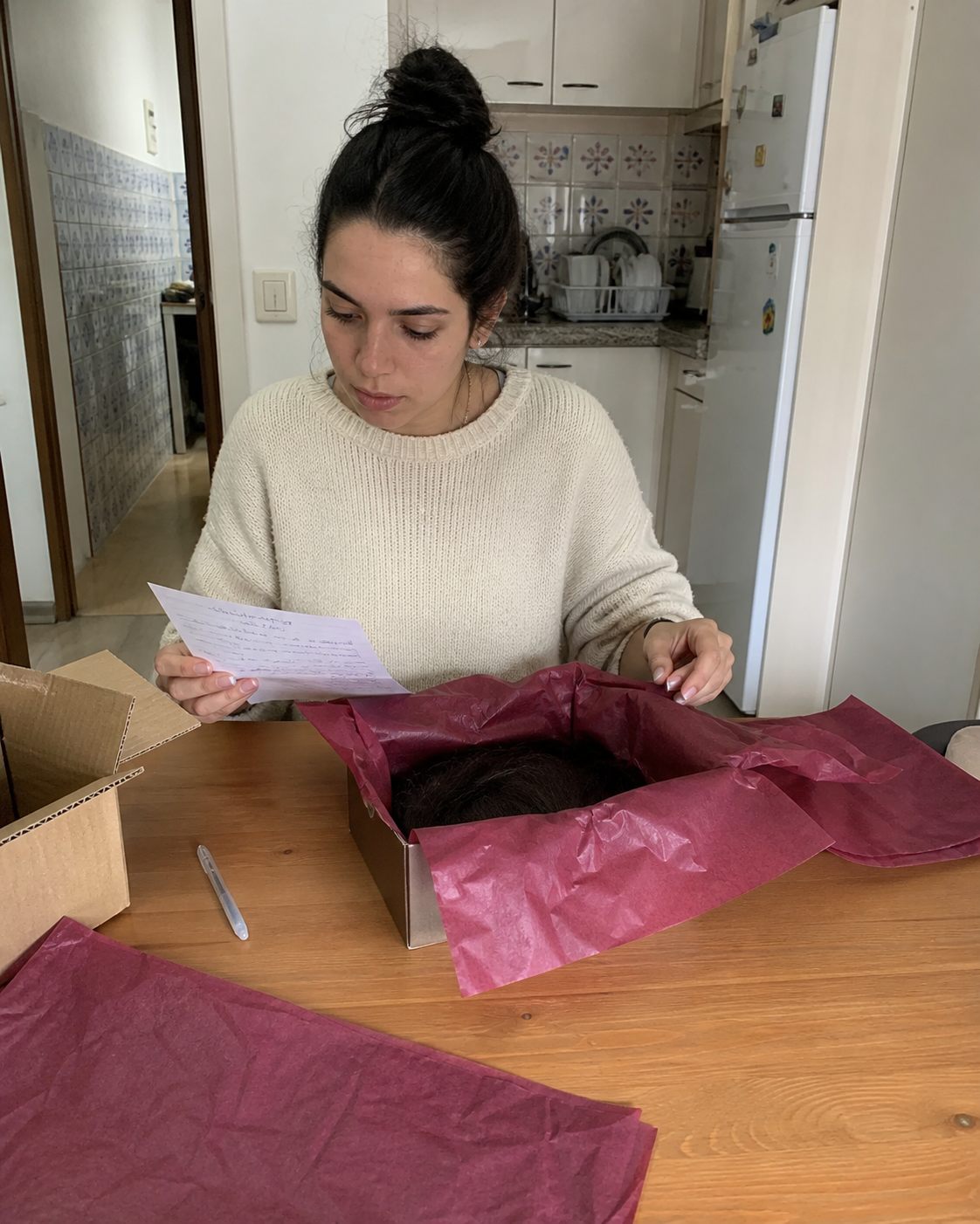 Mulher a preparar a primeira encomenda de peruca em casa